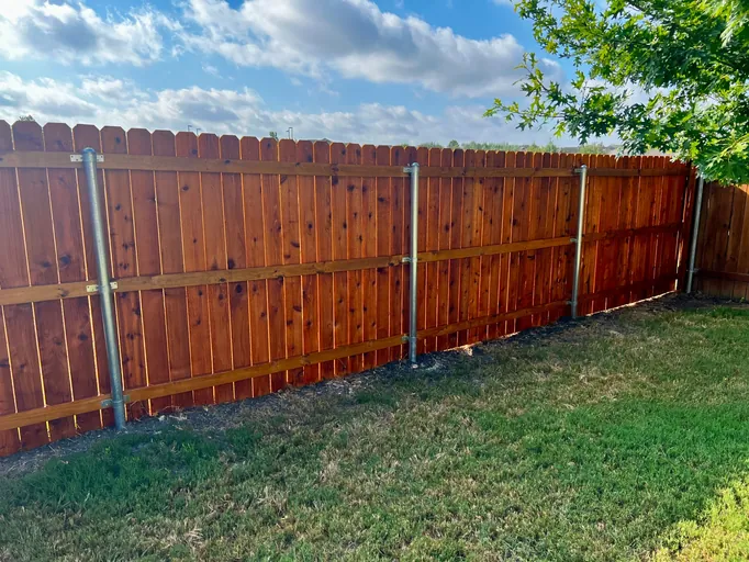 Stained cedar privacy fence with metal posts in Austin, TX